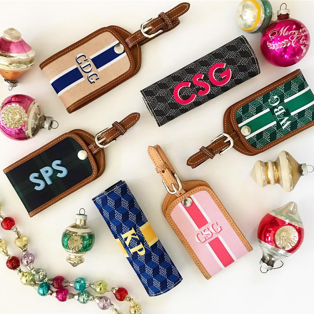 Assortment of custom leather luggage tags with initials on a festive background