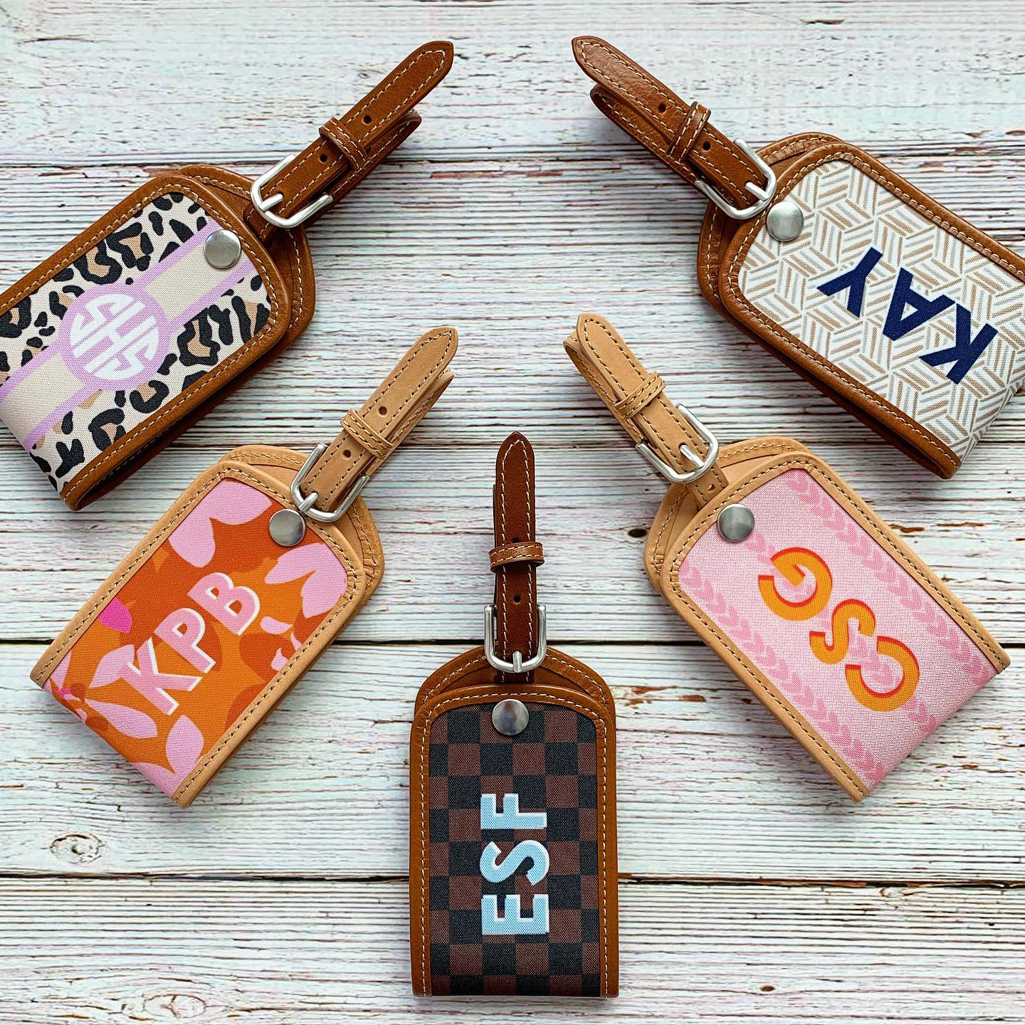 Collection of custom leather luggage tags with various patterns, unique travel accessory