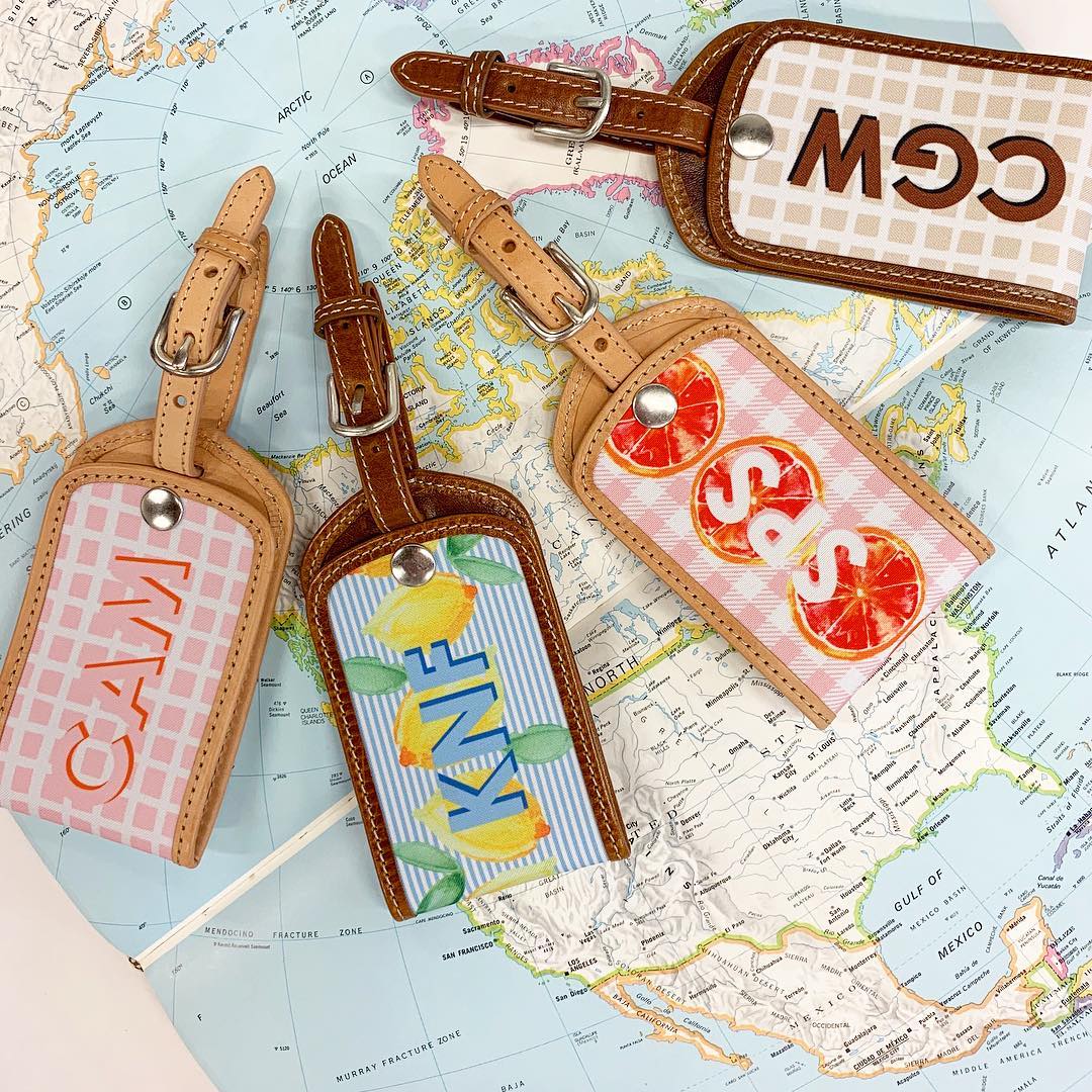 Personalized leather luggage tags on a world map, travel concept