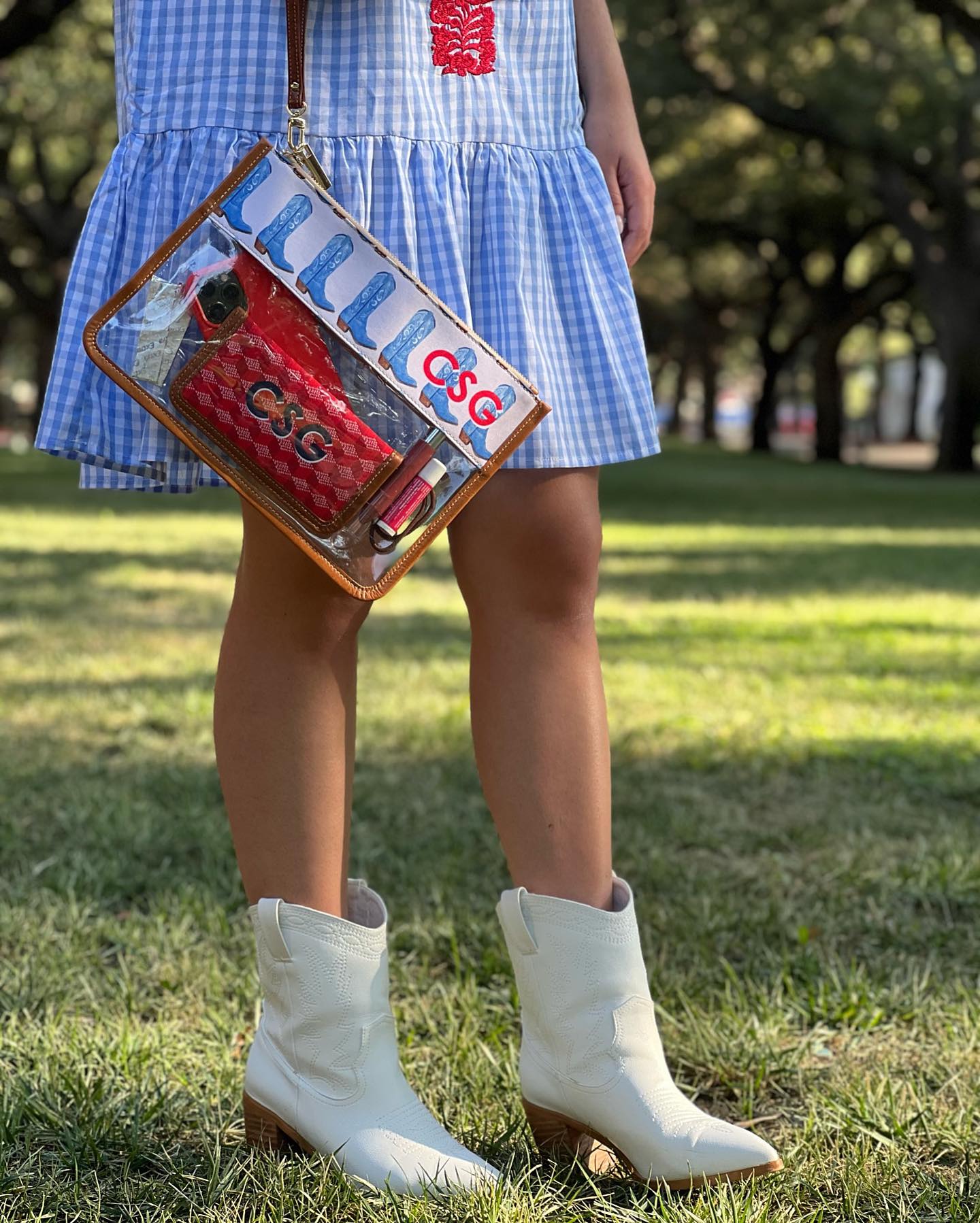 This see-through pouch features a leather top with monogrammed initials and a design of blue boots. Perfect for carrying your phone, makeup, and accessories, it adds a touch of personalized flair to any outfit.